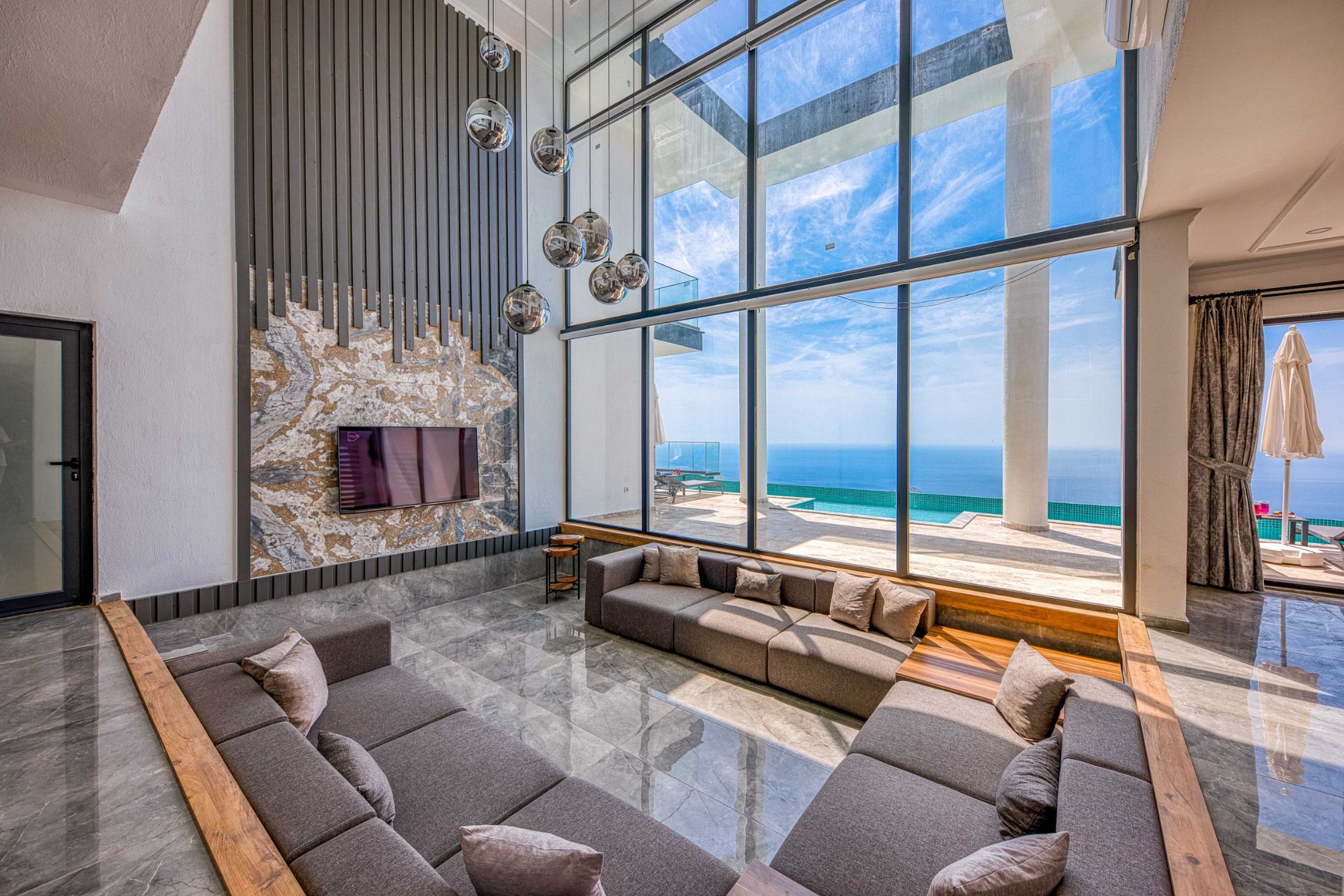 A living room with floor-to-ceiling windows over the sea